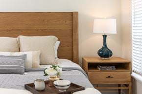 Chaska apartment for rent - a bedroom with a bed with a wooden headboard and a table with a lamp
