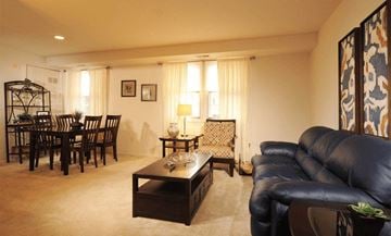 Parkville apartment for rent - A living room with a black leather couch and a wooden coffee table.