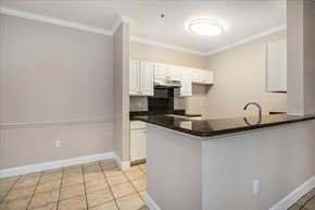 Jacksonville apartment for rent - A kitchen with white cabinets and a black countertop. at Puller Place Apartments, Jacksonville