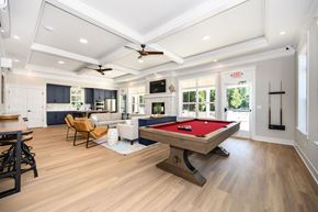 Easton apartment for rent - A pool table is in the middle of a room with a ceiling fan at The Promenade at Easton Apartments, Easton, MD 21601