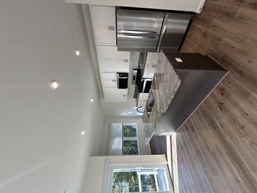 Annapolis apartment for rent - A modern kitchen with a stainless steel refrigerator and wooden ceiling.