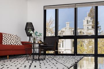 Sacramento apartment for rent - a living room with a large window and a red couch and a black and white