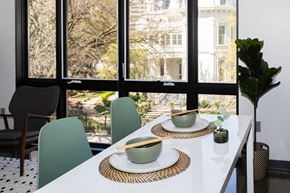 Sacramento apartment for rent - a dining table with two bowls and two chopsticks on it in front of a large window