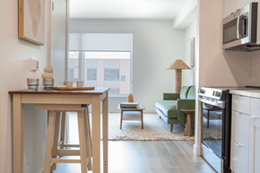 Davis apartment for rent - A kitchen with a bar stool and a table with a tray of bread on it.