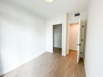 Surrey apartment for rent - A room with a white wall and a wooden floor.