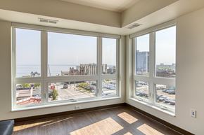 Duluth apartment for rent - A room with a view of a parking lot and buildings outside the window.
