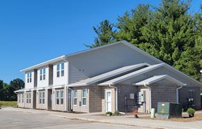 Ottumwa townhouse for rent - A modern building with a grey roof and white walls.