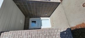 Ottumwa townhouse for rent - A small window on a house with a brown brick wall.