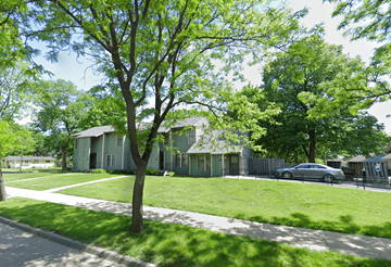 Minneapolis apartment for rent - A tree in front of a house with a car parked in the driveway.