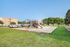 St Paul apartment for rent - A playground with a slide and swings in a grassy area.