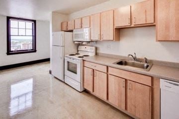 Marshalltown apartment for rent - A kitchen with white appliances and wooden cabinets.