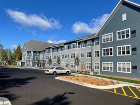 Duluth apartment for rent - A white car is parked in a parking lot in front of a grey building.