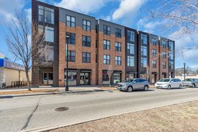 Minneapolis apartment for rent - A modern brick building with a parking lot in front.