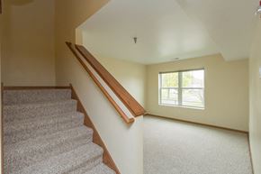 Waterloo townhouse for rent - A staircase with a wooden handrail leads up to a window.