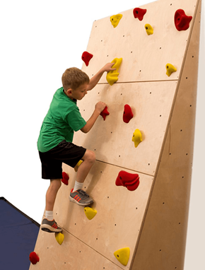 Minneapolis apartment for rent - A boy climbing a wall with red and yellow holds.