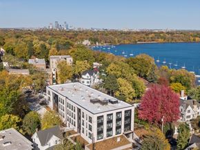 Minneapolis apartment for rent - A large white building with a grey roof is surrounded by trees in autumn colors.