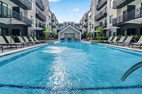 Bentonville apartment for rent - A swimming pool in a residential area with lounge chairs around it.