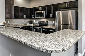 Papillion apartment for rent - Extra countertop space with dark cabinets at The Apartments at Lux 96 in Papillion, NE