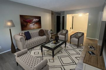 Omaha apartment for rent - A living room with a white couch, a coffee table, and a painting on the wall.