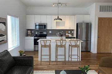 Omaha apartment for rent - A kitchen with a black sofa and a bar stool.