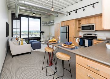 Des Moines townhouse for rent - A kitchen with a bar stool and a counter with food on it.