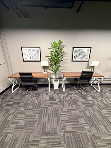 Omaha apartment for rent - A room with a grey carpet and a wooden table with two chairs.
