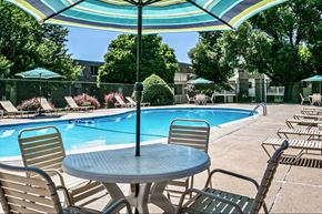 Bellevue apartment for rent - a swimming pool with a table and chairs under an umbrella