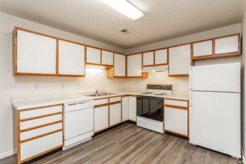 Sioux City apartment for rent - A kitchen with white appliances and wooden accents.