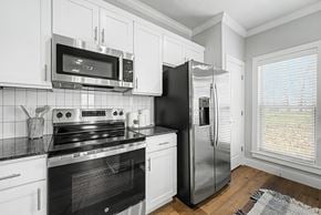 Rogers apartment for rent - A black refrigerator is in a white kitchen.
