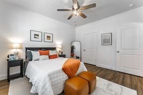 Pea Ridge apartment for rent - A bedroom with a large bed and a ceiling fan.