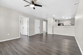Bentonville apartment for rent - A spacious room with a ceiling fan and wooden flooring.