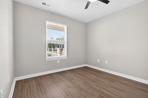 Bentonville apartment for rent - A room with a window showing a view of a building and trees outside.