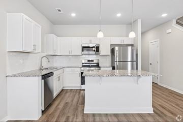 Springdale townhouse for rent - A modern kitchen with white cabinets and stainless steel appliances.