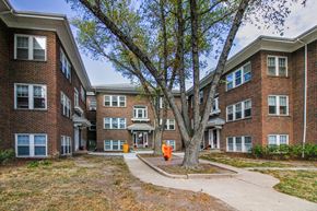 Omaha apartment for rent - an apartment building with a sidewalk and a tree in front of it