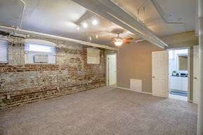 Omaha apartment for rent - an empty room with a brick wall and a ceiling fan