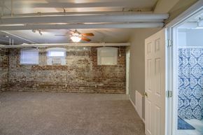 Omaha apartment for rent - the living room of a home with a brick wall and a ceiling fan