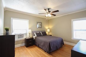 Omaha apartment for rent - a bedroom with a large bed and a ceiling fan