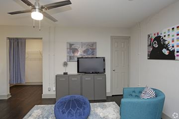 Kansas City apartment for rent - A living room with a blue chair and a television.