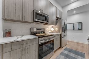 Bentonville apartment for rent - A modern kitchen with wooden cabinets and stainless steel appliances.