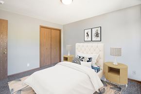 Lincoln apartment for rent - a bedroom with a white bed and a wooden closet