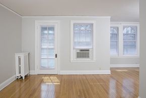 Omaha apartment for rent - an empty living room with a door and three windows
