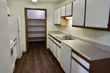 Blair apartment for rent - a kitchen with white cabinets and a sink and a refrigerator