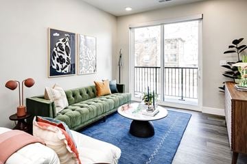 Omaha apartment for rent - A living room with a green couch and a white coffee table.