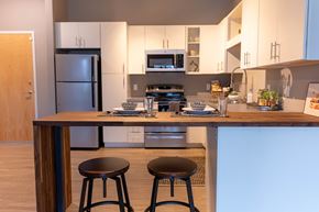 Omaha apartment for rent - Studio, one, and two-bedroom apartment featuring stainless steel appliances, artistic industrial design, custom butcher block island, in-unit washer and dryer, and more at Benson Lights Apartments in Benson, NE