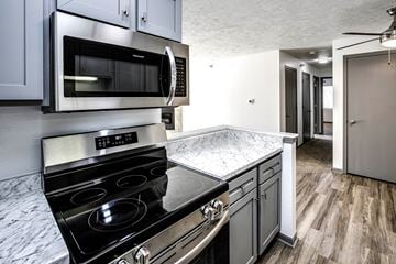 Council Bluffs apartment for rent - a kitchen with stainless steel appliances and marble counter tops