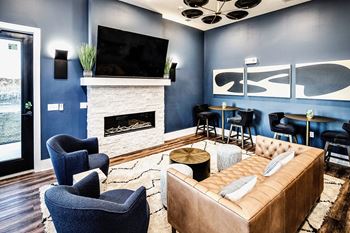 Resident lounge area with fireplace, bar, and kitchen area