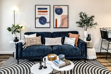 Papillion apartment for rent - A living room with a blue couch and two framed artworks on the wall.