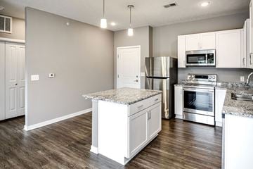 Omaha apartment for rent - a kitchen with white cabinets and stainless steel appliances