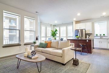 Omaha apartment for rent - a living room with a couch and a kitchen in the background