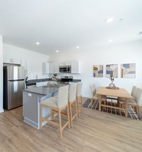 Rogers townhouse for rent - a kitchen and dining area with stainless steel appliances and a wooden table